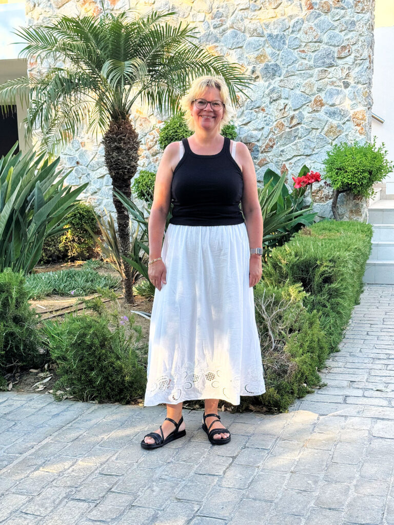 Urlaubsoutfits- weißer Maxirock mit Broderie Anglaise-schwarzes Ripptop-schwarze Sandalen