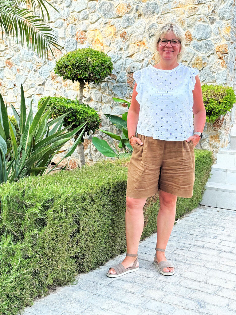 Urlaubsoutfits-braune Leinenshorts-weiße Bluse mit Lochstickerei-olivfarbene Sandalen