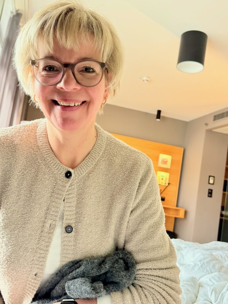 Outfitinspirationen 8/26-kalt-wechselhaft-cozy-lifewithaglow-Hose coated schwarz-Boucléstrickjacke in Beige-