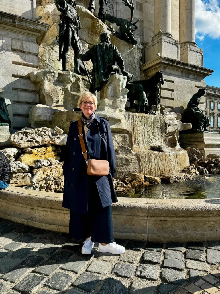 Outfitinspirationen 16/26-von brr bis hui-lifewithaglow-weite dunkle Jeans-Strickjacke beige in leichtem Bouclé-weiße Sneaker-Trenchcoat dunkelblau