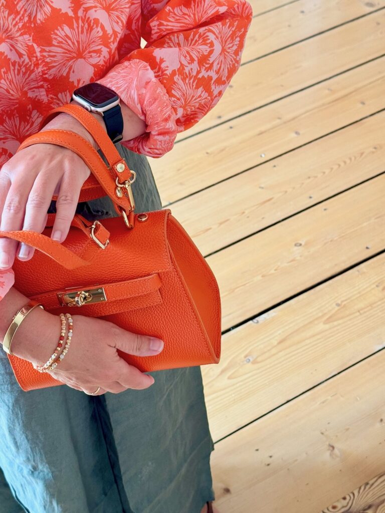 Outfitinspirationen-Sommeroutfits bei wechselhaften Temperaturen-lifewithaglow-Weite Leinenhose oliv-Bluse orange mit weißen Blumen-Tasche orange