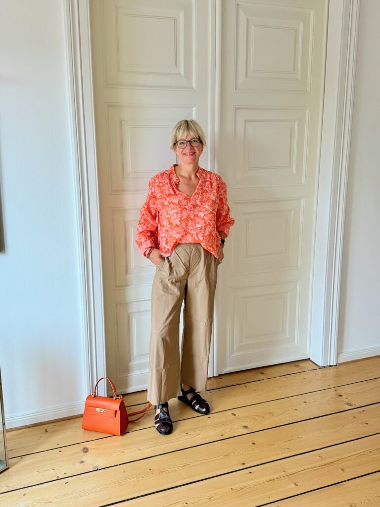 Outfitinspirationen-Sommerlooks im Übergang-lifewithaglow- Armbänder Pera Schmuckmanufaktur- Fisherman Sandalen-orangefarbene Tasche- beige weite Hose-Bluse orange mit Blumenmuster
